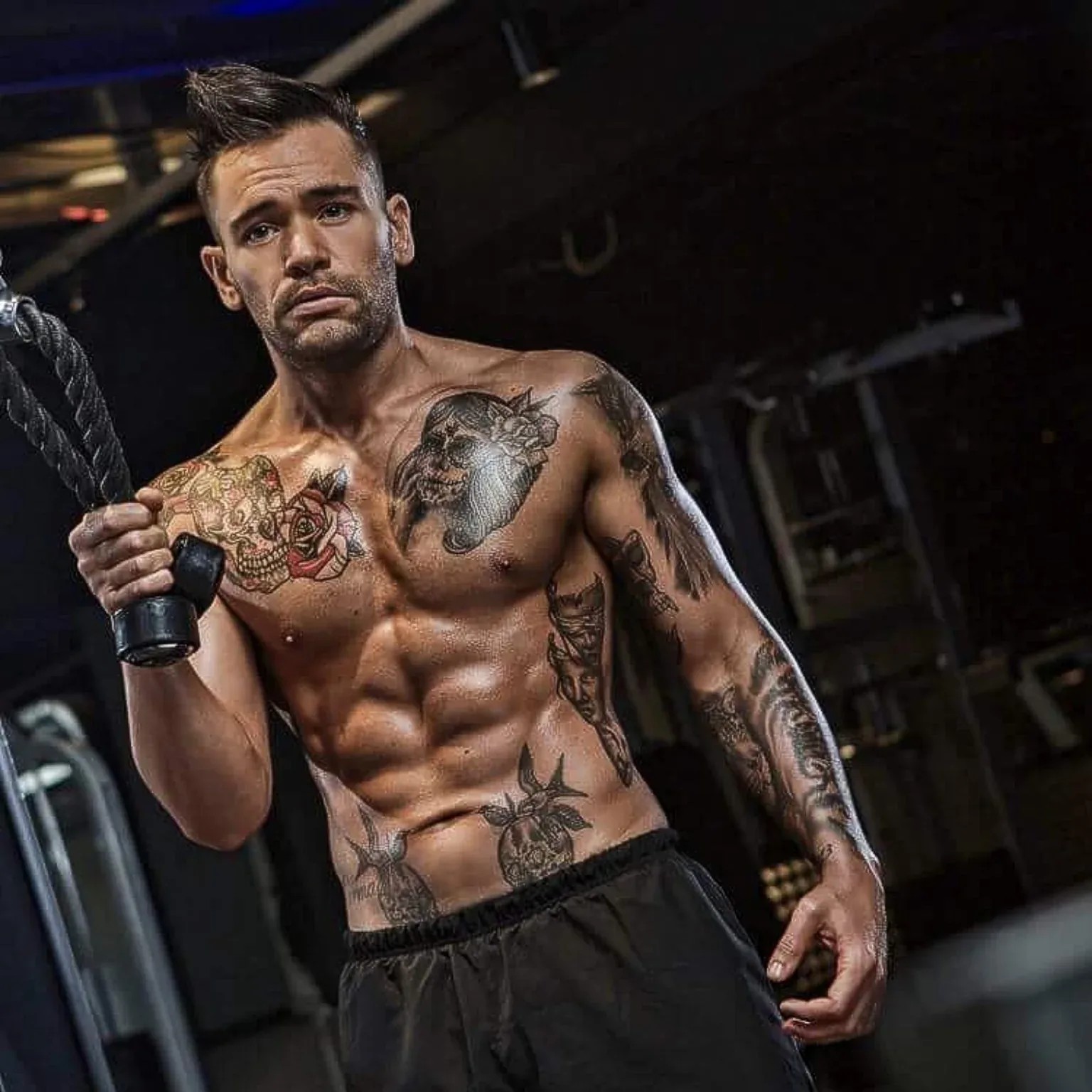 Coach Pete Ryan holding gym rope in a dark training environment
